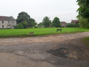 alt="Latteridge Green with Latteridge House on the left and Heals Farm on right"