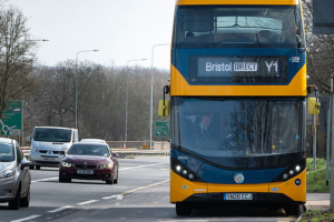 A bus waits at a bus stop on the busy Bristol ring road.