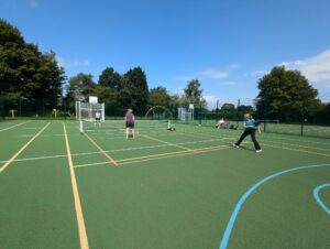 alt="people playing pickleball on an outdoor court"